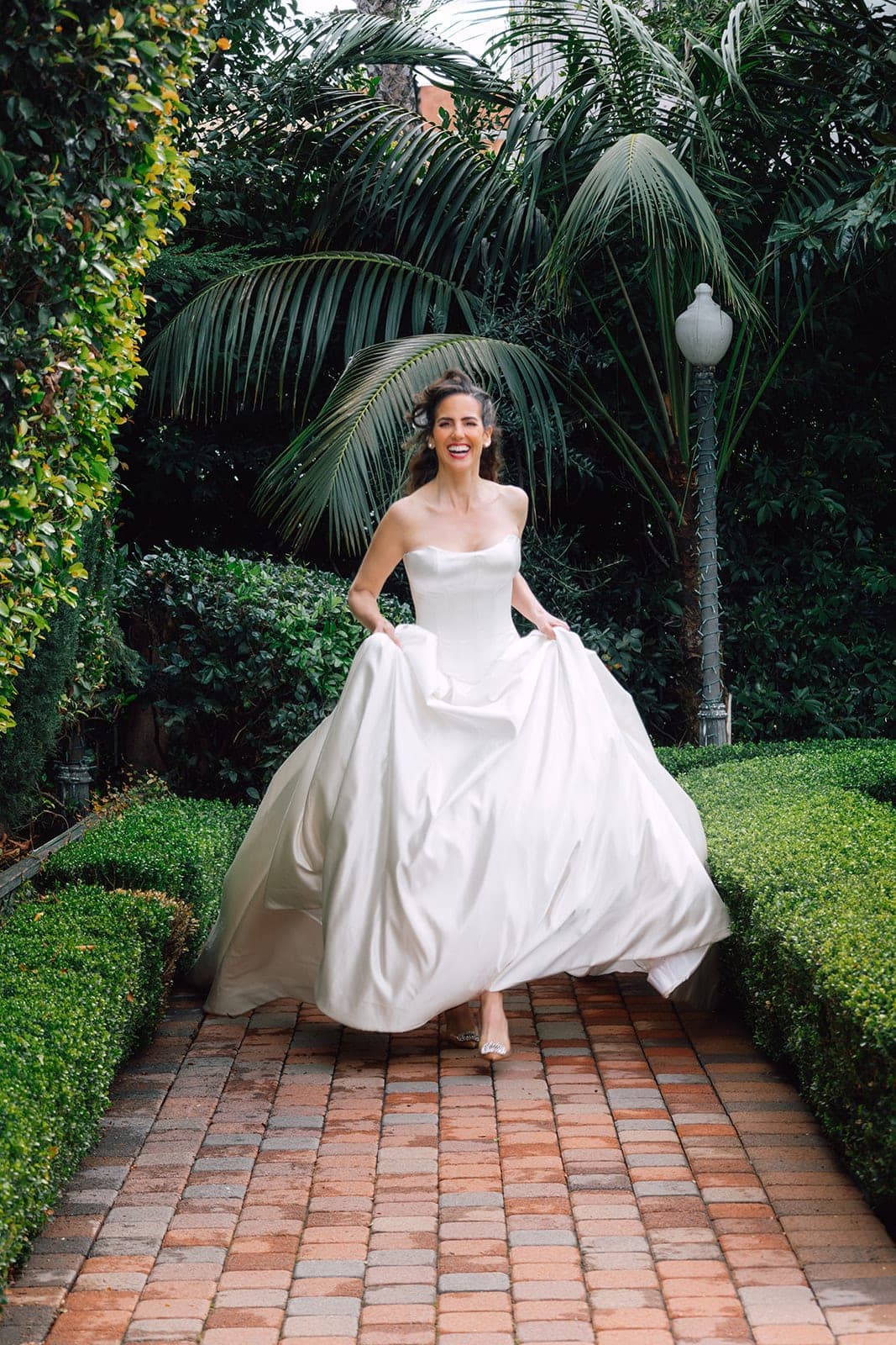The Camille silk satin gown in a garden