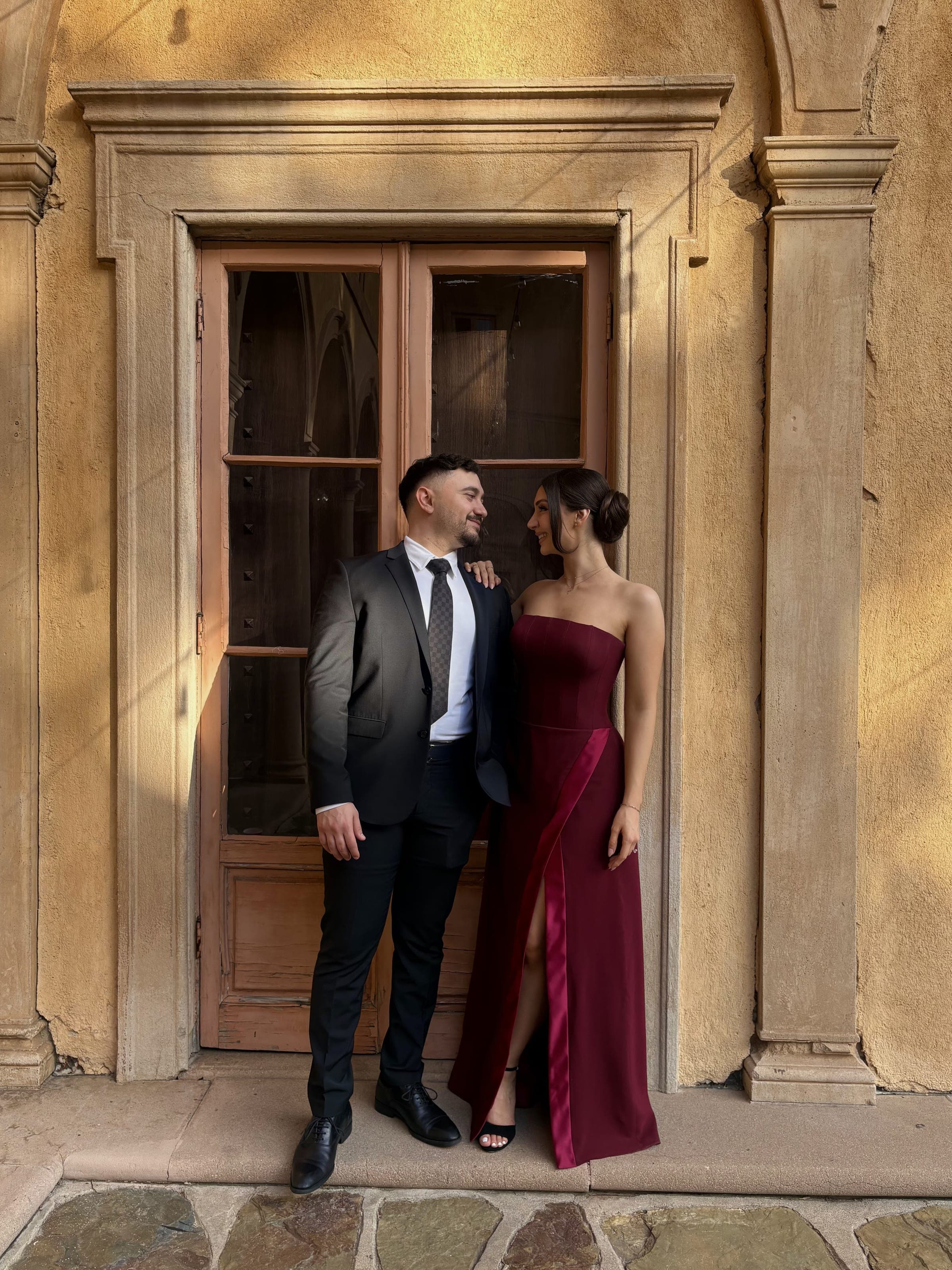 Burgundy evening gown styled beside a black tuxedo